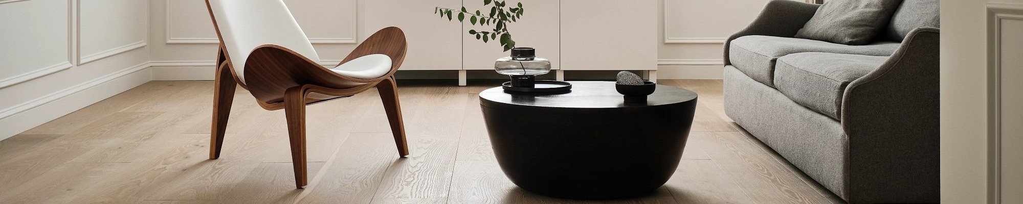 living room with hardwood floor and black coffee table with a plant on it in a glass vase from Carneys Carpet Gallery in Jeffersontown, KY