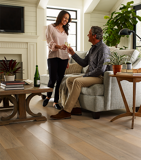 people in living room with hardwood flooring from Carneys Carpet Gallery in Jeffersontown, KY