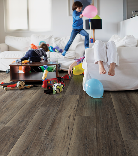 kids playing in room with wood-look laminate flooring from Carneys Carpet Gallery in Jeffersontown, KY